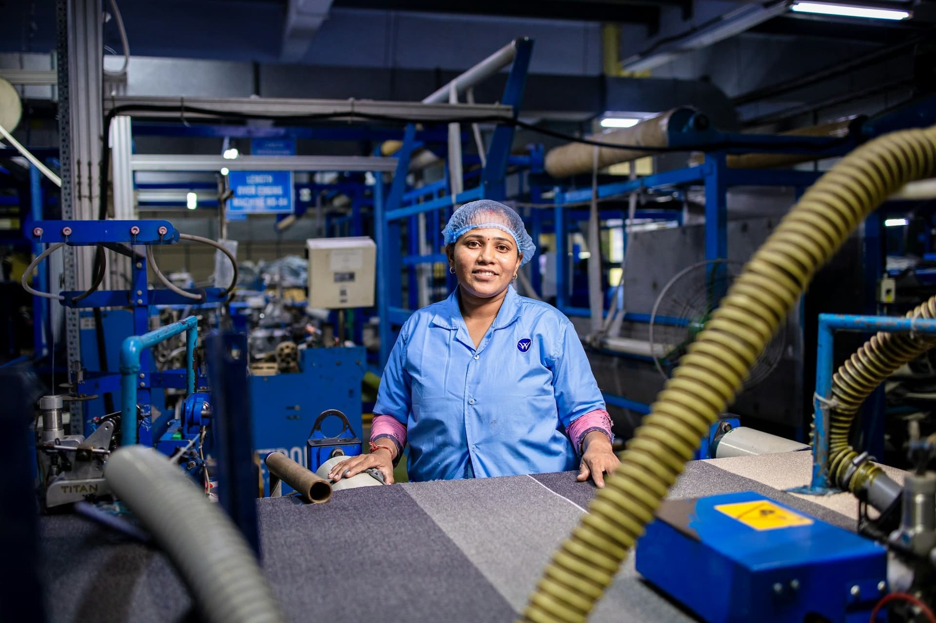 Technician operating production equipment on a factory floor